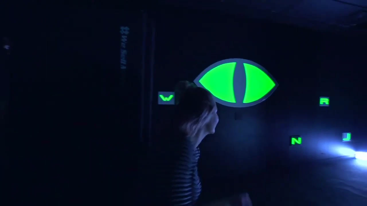 A player moving past a glowing eye in a stealth challenge